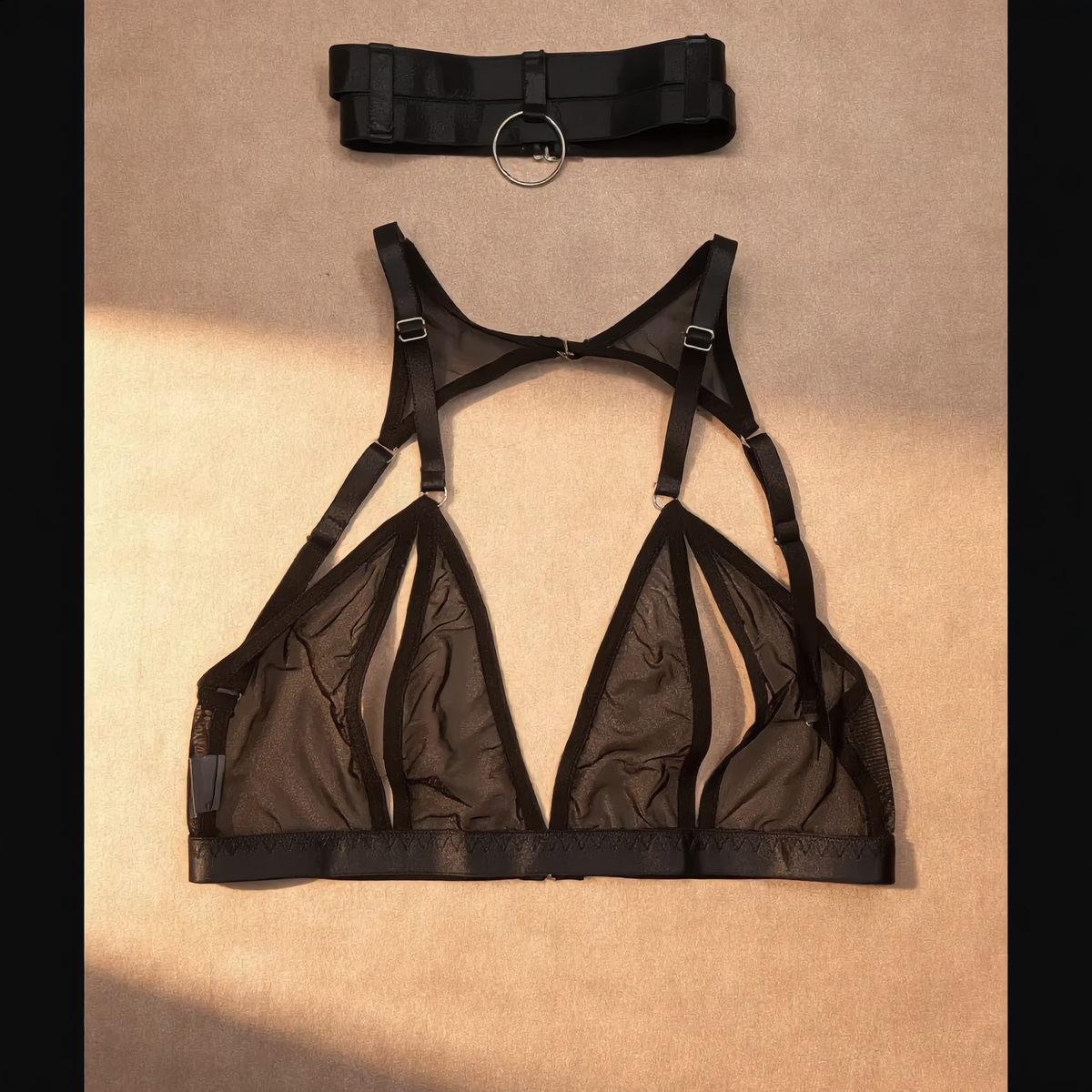 Conjunto Vittoria preto: Sutiã em mesh ultrafino sem bojo com recortes estratégicos e choker de anel, vista frontal.