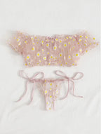 Conjunto Luiza rosa. Top ombro a ombro sem bojo e calcinha de amarrar, ambos em renda floral com margaridas. Vista frontal.