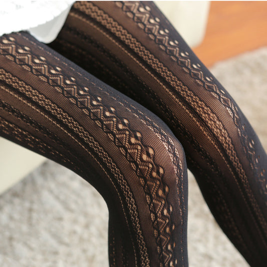 Meia-calça Lilia preta NuAuge, detalhe. Translúcida, com padrão de renda jacquard em listras verticais que alongam as pernas.