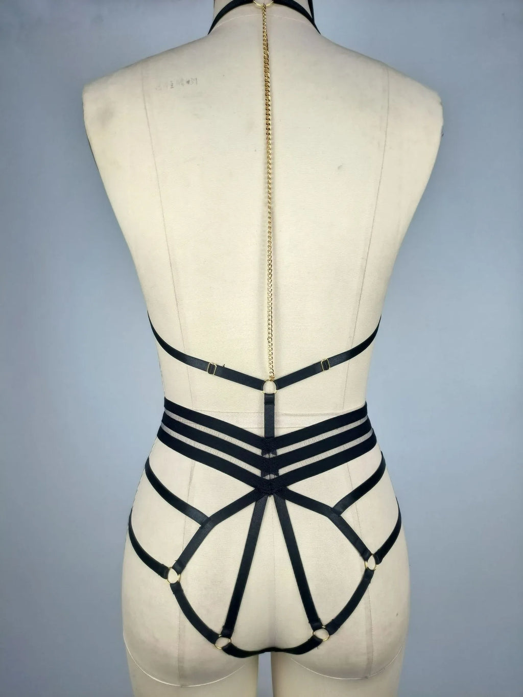 Body Camila preto, vista costas. Lingerie com alças ajustáveis, design cage, corrente dourada e anéis.