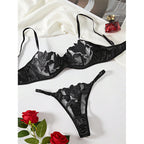 Conjunto Penelope preto: sutiã meia-taça com bojo fino, renda bordada floral e tule transparente; calcinha fio dental. Vista frontal.