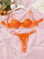 Conjunto Penelope Laranja, vista frontal. Sutiã meia-taça bojo fino, renda bordada e tule. Calcinha fio dental com renda.