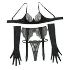 Conjunto Cassiopeia preto, vista frontal. Sutiã com aro e renda bordada, calcinha fio, cinta-liga e luvas transparentes.