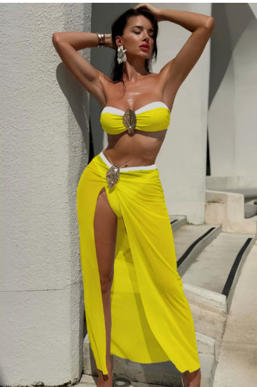 Frente: Conjunto Santorini amarelo NuAuge. Top tomara-que-caia com bojo, broche dourado e faixa branca. Saída de praia longa.