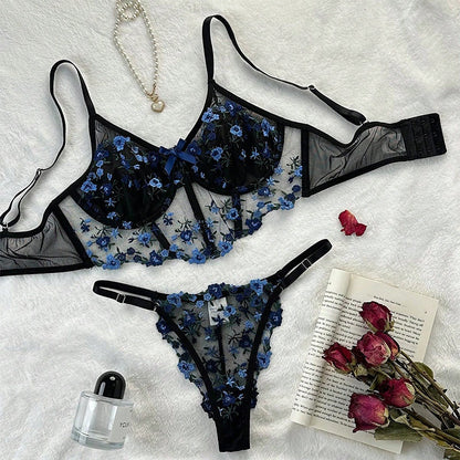 Conjunto Mirella Preto e Azul, vista frontal. Sutiã sem bojo, com aro, tule e renda floral azul; calcinha fio dental.