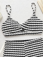 Biquíni Riviera listrado preto e branco, frente. Top cropped twist frontal, alças finas e shorts de cintura alta com tecido franzido.