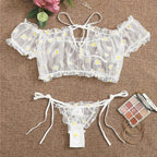 Conjunto Luiza Branco, top ombro a ombro e calcinha fio dental de renda floral com margaridas e babados.