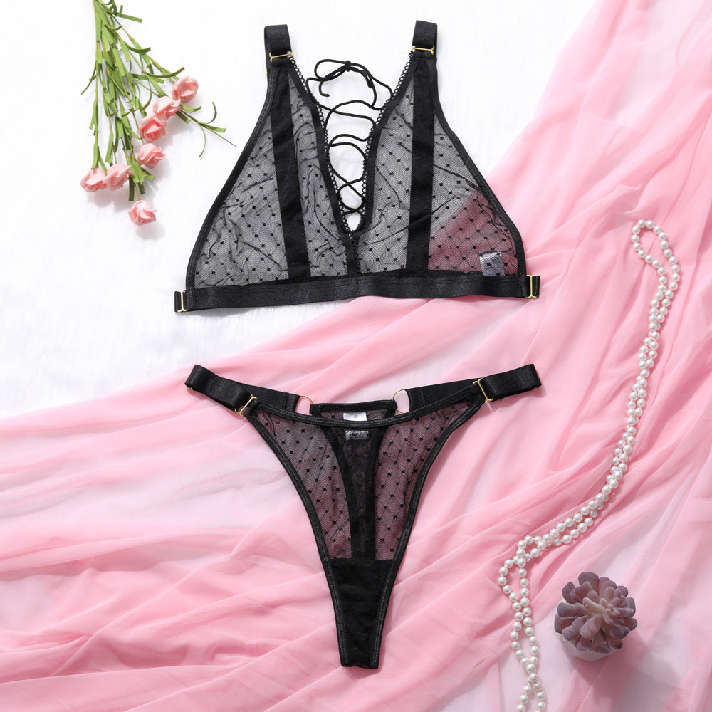 Conjunto Bianca preto, bralette renda transparente poá sem bojo/aro com amarrilho e calcinha fio dental. Vista frontal.