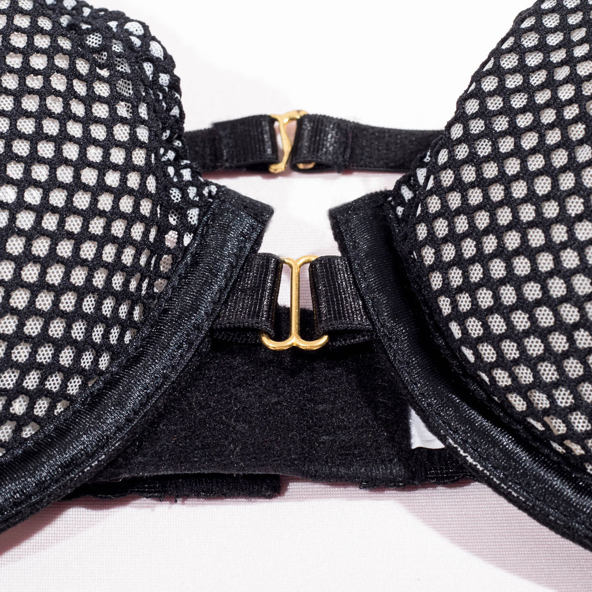 Detalhe sutiã preto Adriana NuAuge: fecho frontal dourado, copas em tule rede com forro claro. Design com amarração ajustável.