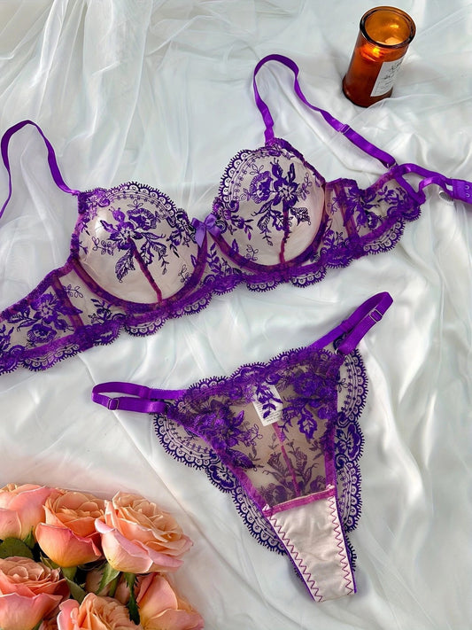 Conjunto Florinda Roxo de frente. Sutiã meia-taça com aro, bojo estruturado e tule bordado floral. Calcinha fio dental.