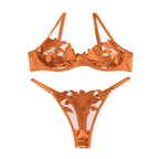 Conjunto Penelope laranja escuro de frente. Sutiã meia-taça, bojo fino, renda bordada e tule transparente. Calcinha fio combinando.