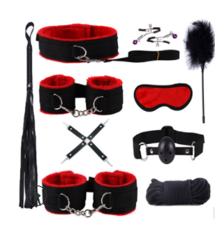 Vista detalhada do Kit Liaison preto e vermelho da NuAuge, com algemas, coleira, mordaça, chicote e acessórios sensuais de nylon.