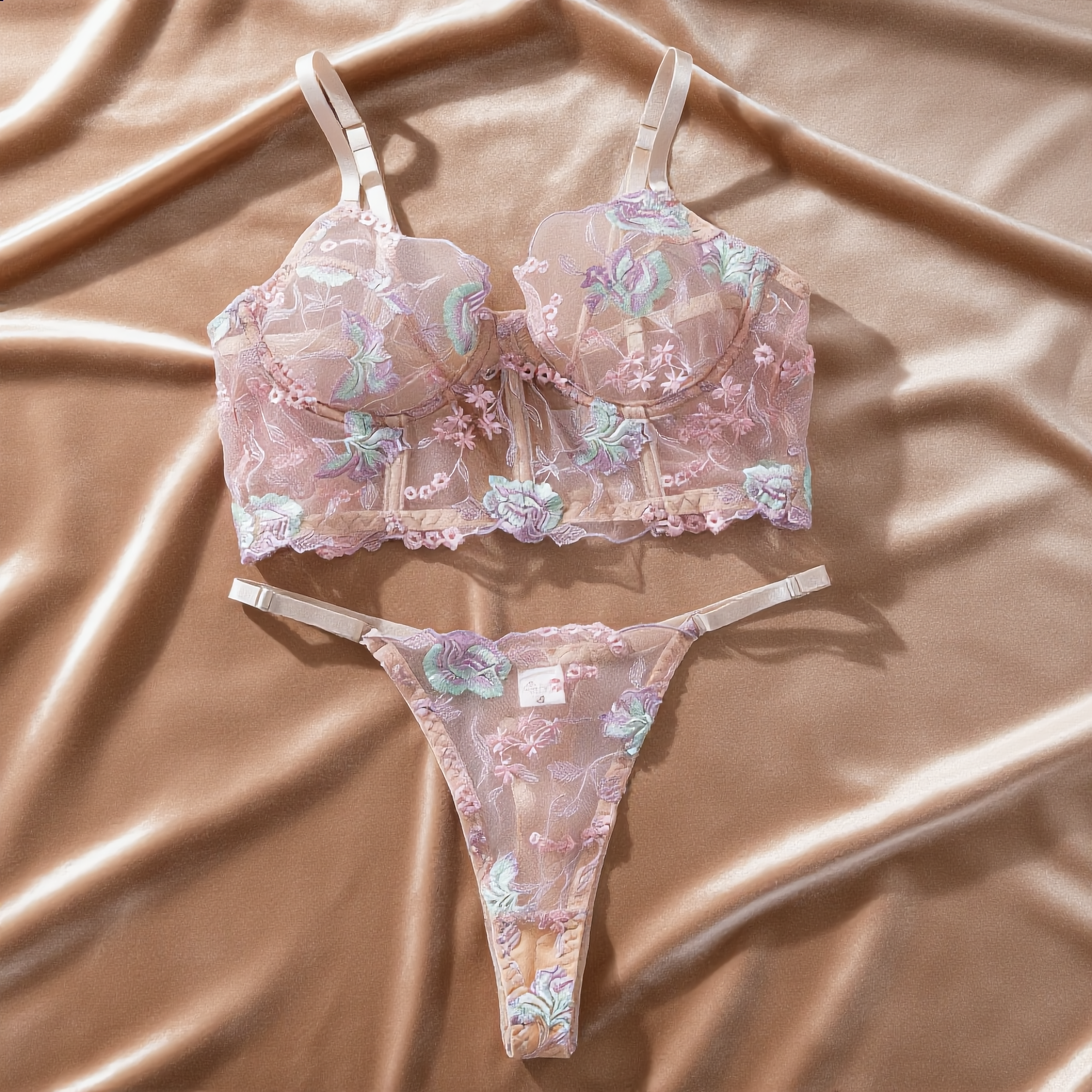 Vista frontal: Conjunto Aurora rosa em poliéster e elastano, sutiã bustier com aro, renda floral bordada e calcinha fio.