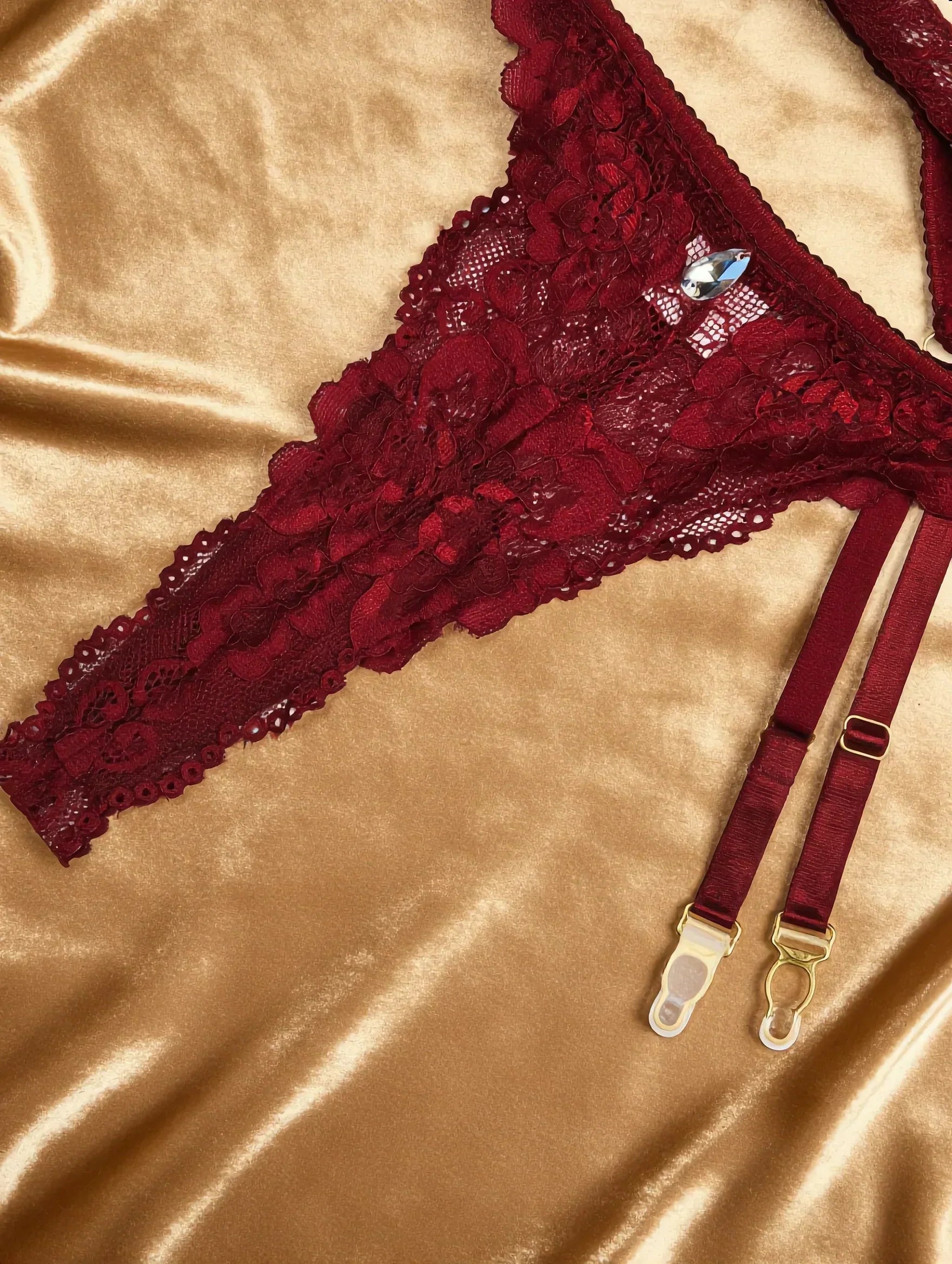 Detalhe Conjunto Rubi Vinho: calcinha fio dental de renda, detalhe cristal gota e ligas com fivelas douradas.